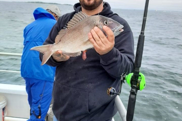a person holding a fish on a boat in the water