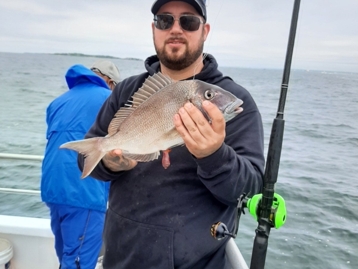 a person holding a fish on a boat in the water